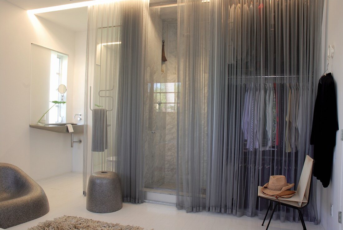 Moderner Ankleidebereich und Badezimmer mit grauem transparentem Vorhang vom Schlafzimmer aus begehbar