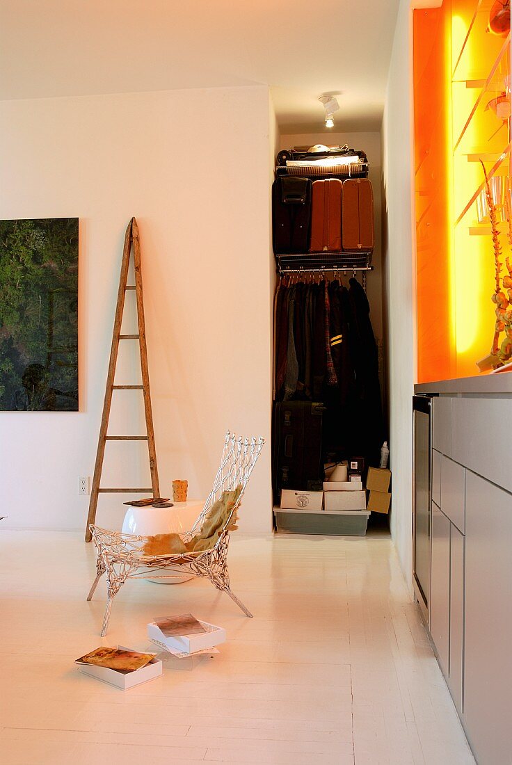 Moderner Wohnbereich mit Garderobennische und orangegelber Lichtinstallation über grauem Sideboard