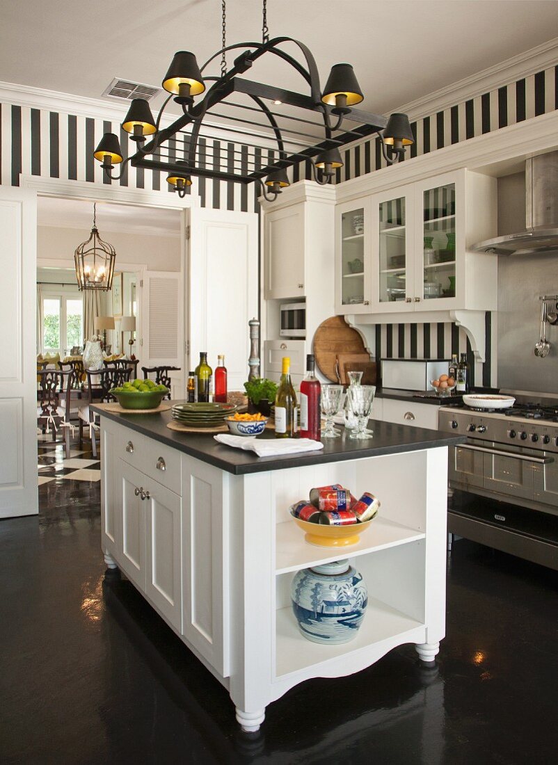 Elegante weiße Landhausküche mit dunklem Boden und schwarz-weiß gestreifter Tapete
