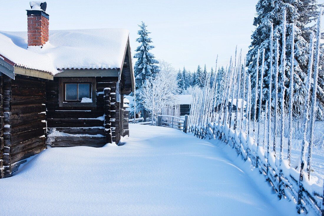 Skandinavisches Blockhaus in verschneiter Winterlandschaft