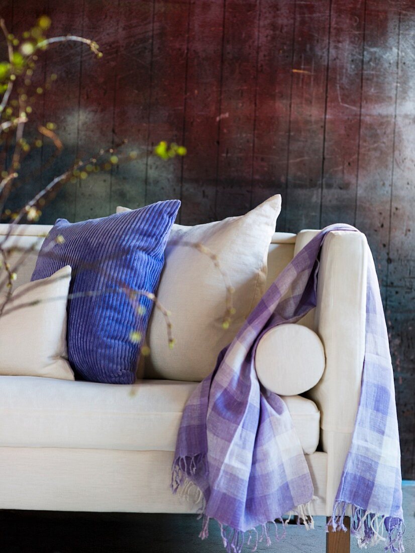 Various scatter cushions and checked scarf on white sofa