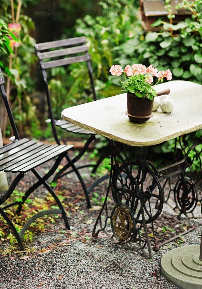 Unusual garden table made from stone table top on antique sewing machine base
