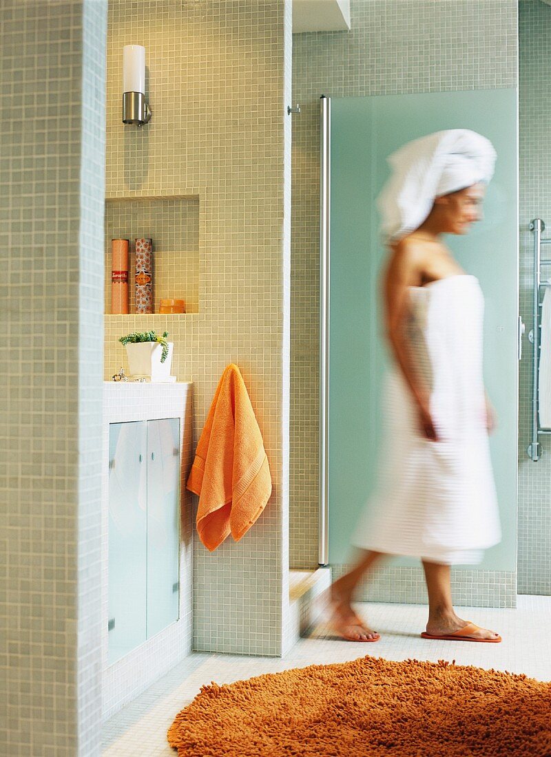 Woman wrapped in towels leaving shower
