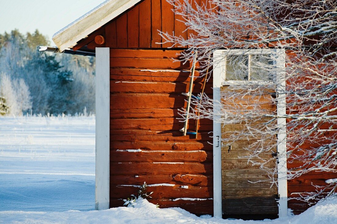 Schwedisches Holzhäuschen auf schneebedecktem Grund
