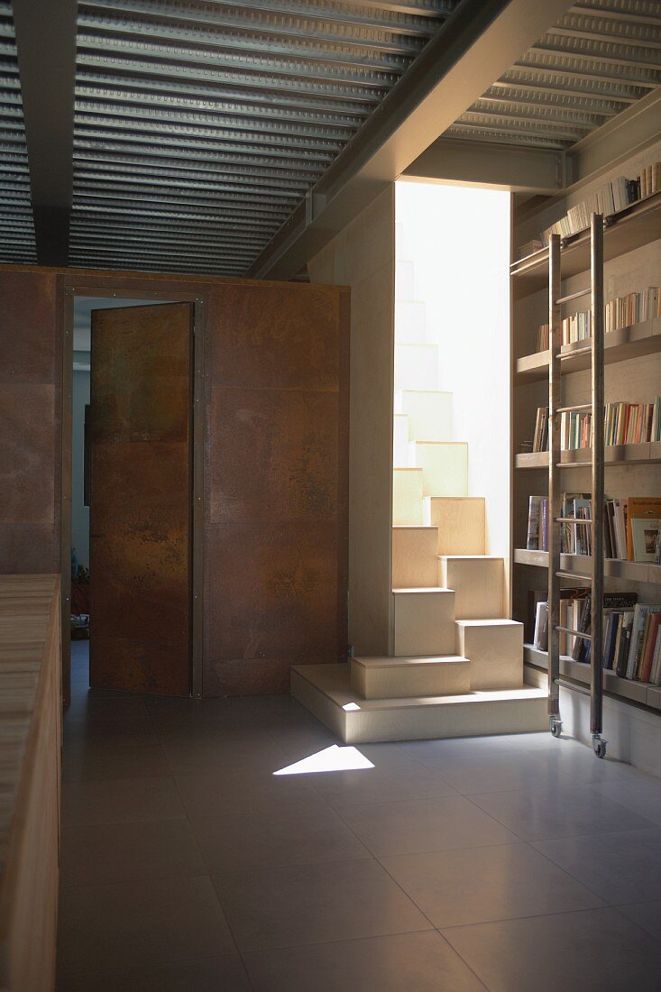 Puristische Bibliothek mit offener Metalldachkonstruktion und sonnengefluteter, kubisch geformter Sambatreppe