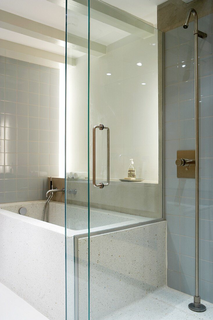 Indirekte Beleuchtung in Badezimmer mit grauen Wandfliesen und verschiebbarere Glastrennwand