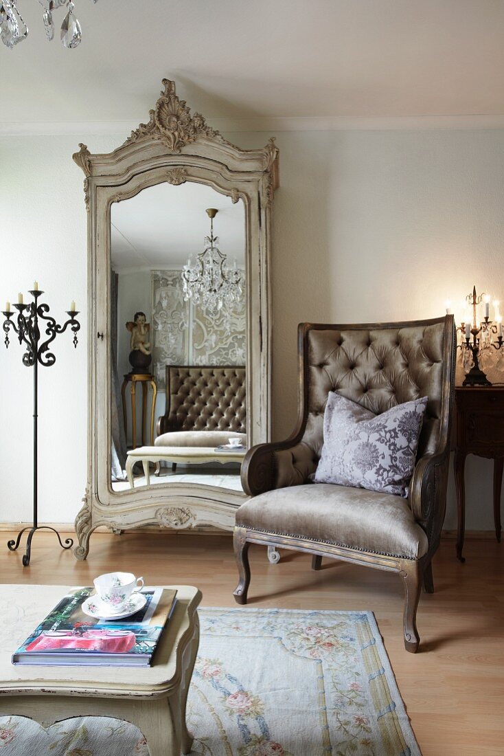 Sessel im klassizistischen Stil neben antikem Schrank mit Spiegeltür