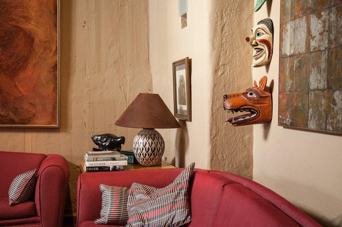 Wohnzimmerecke mit Ethno-Masken an rustikaler Wand
