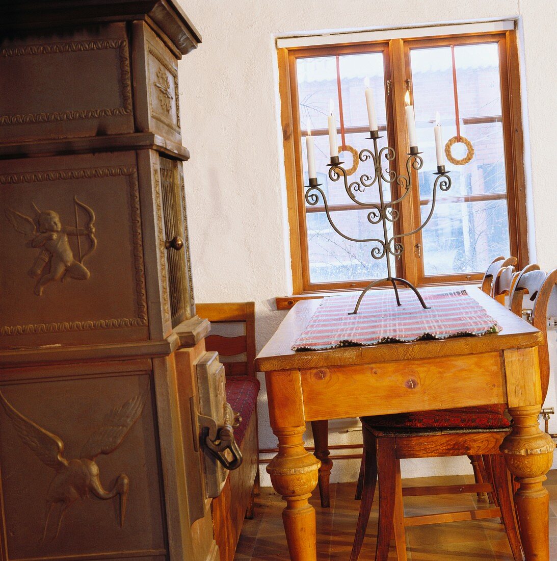 Esszimmer mit antikem Kaminofen, Esstisch und Sitzbank in skandinavischem Stil