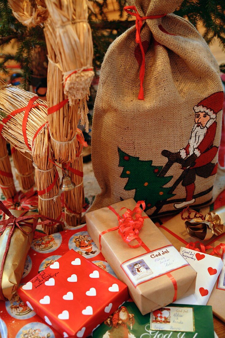 Tierfigur aus Stroh, ein Jutesack und Weihnachtsgeschenke zu Weihnachten