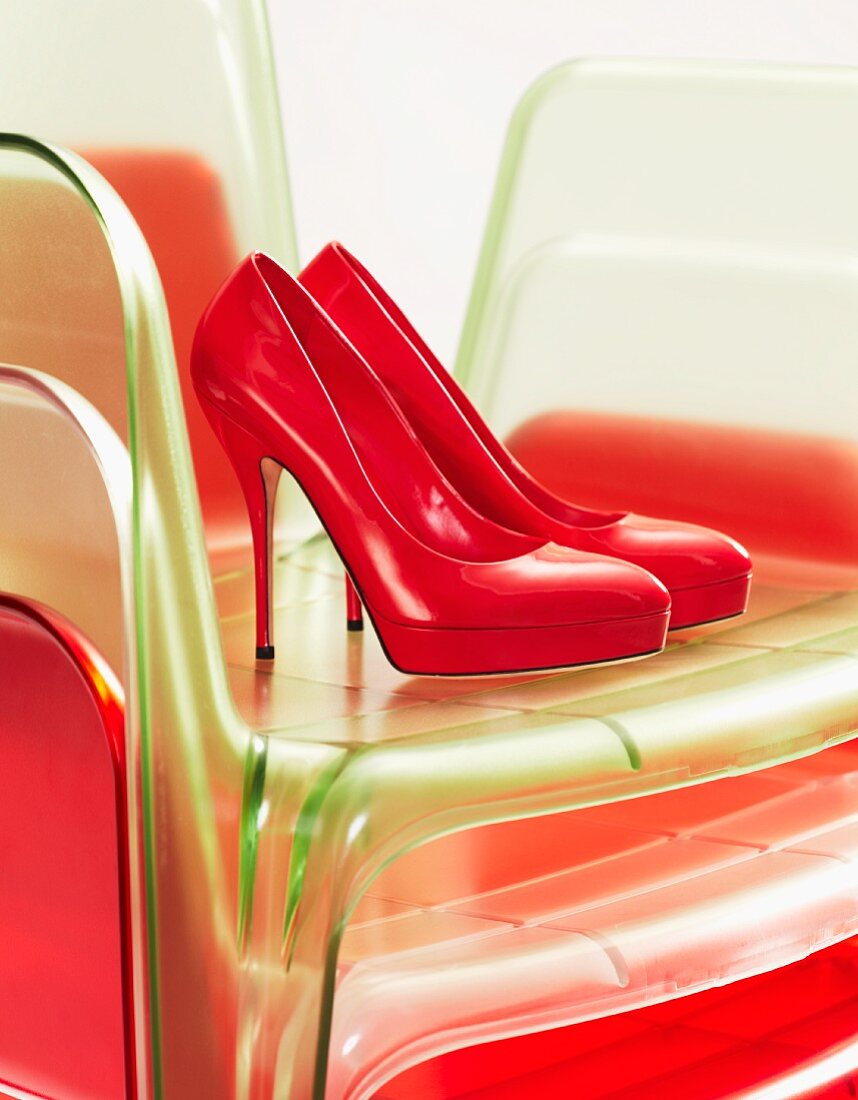 Red high-heeled shoes on stacked plastic chairs