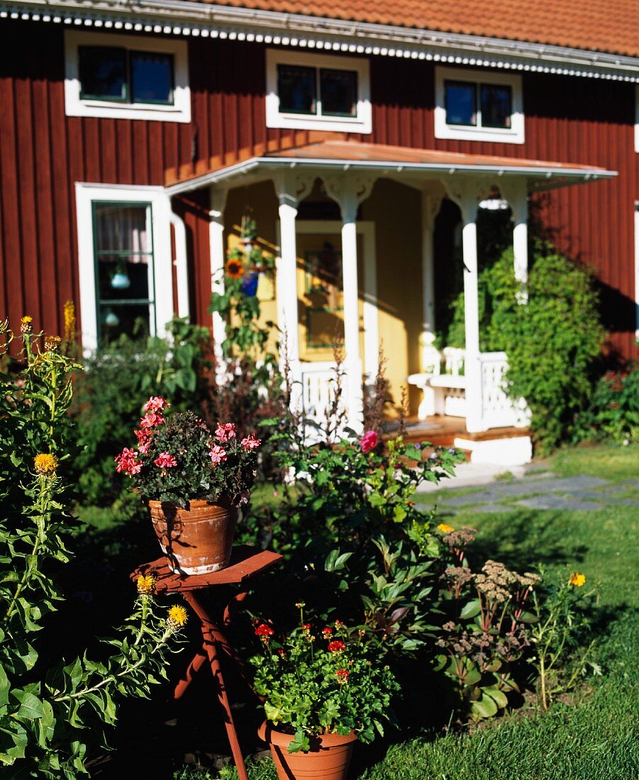 Rotes schwedisches Holzhaus mit Eingangsveranda