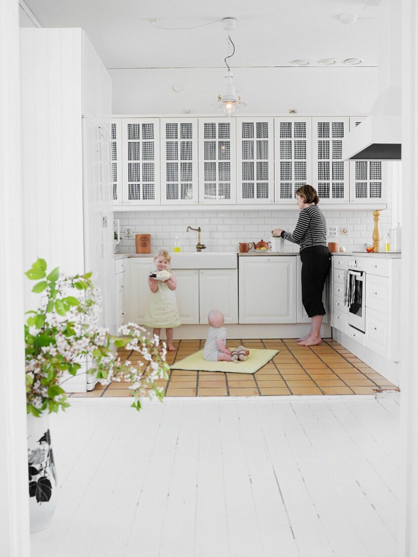 Mother and children in white, Scandinavian-style kitchen