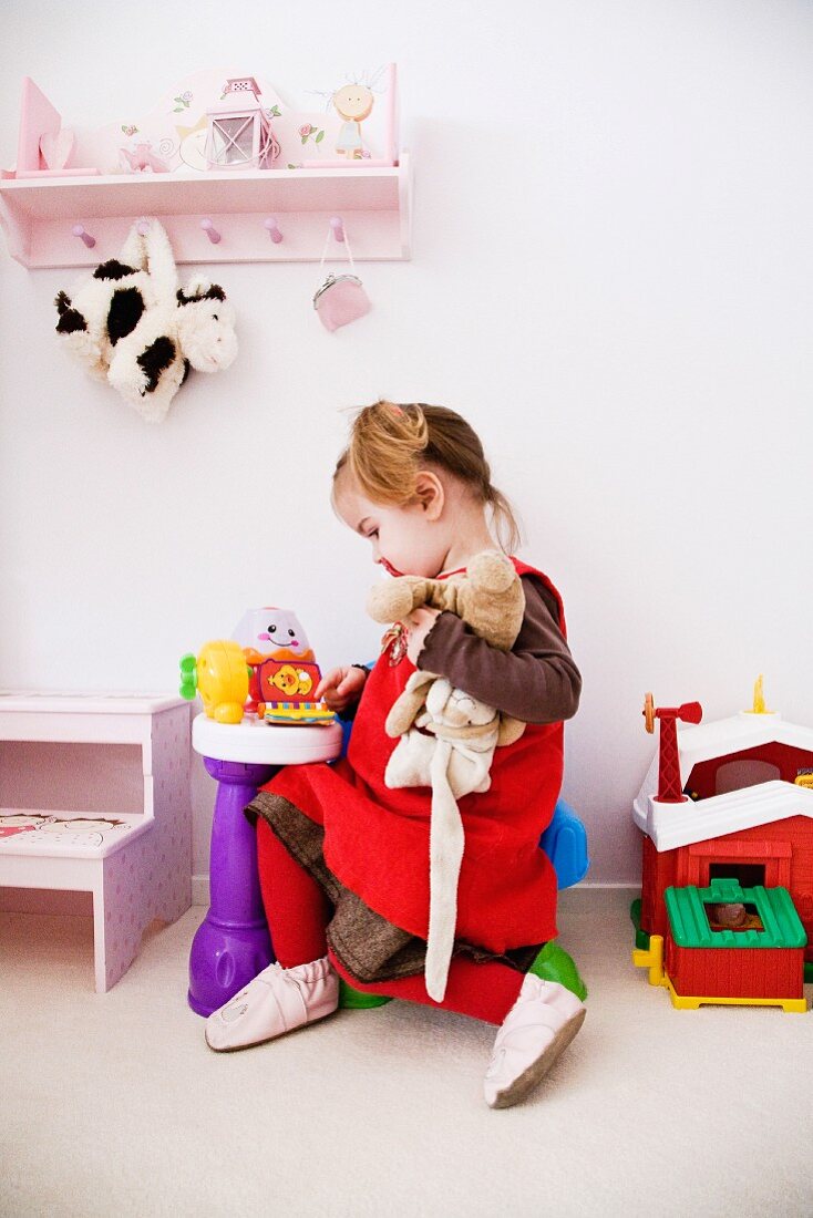 Little girl playing in child's bedroom
