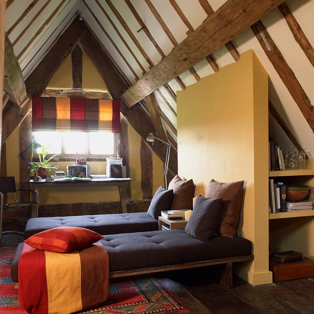 Modern bedroom with practical fittings under rustic roof structure in half-timbered house