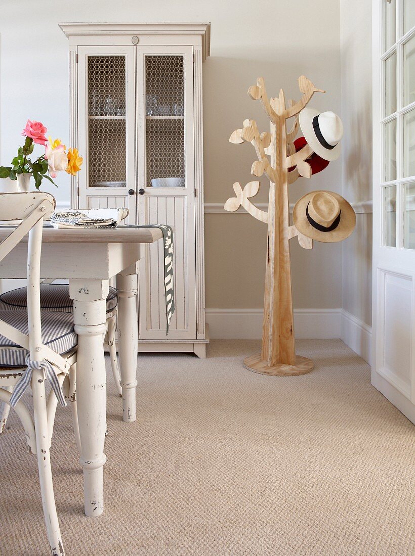 Stilisierte Baumfigur als Garderobenständer, Geschirrschrank und Essplatz im skandinavischen Landhausstil