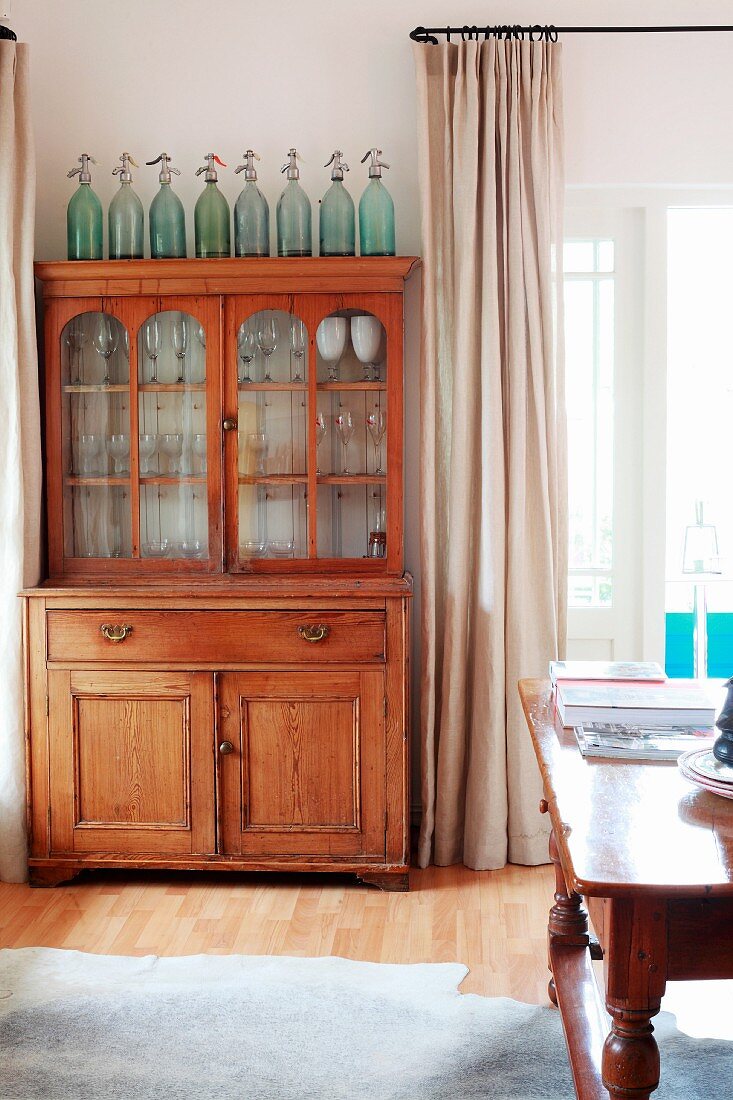 Antique, glass-fronted wooden dresser in living room