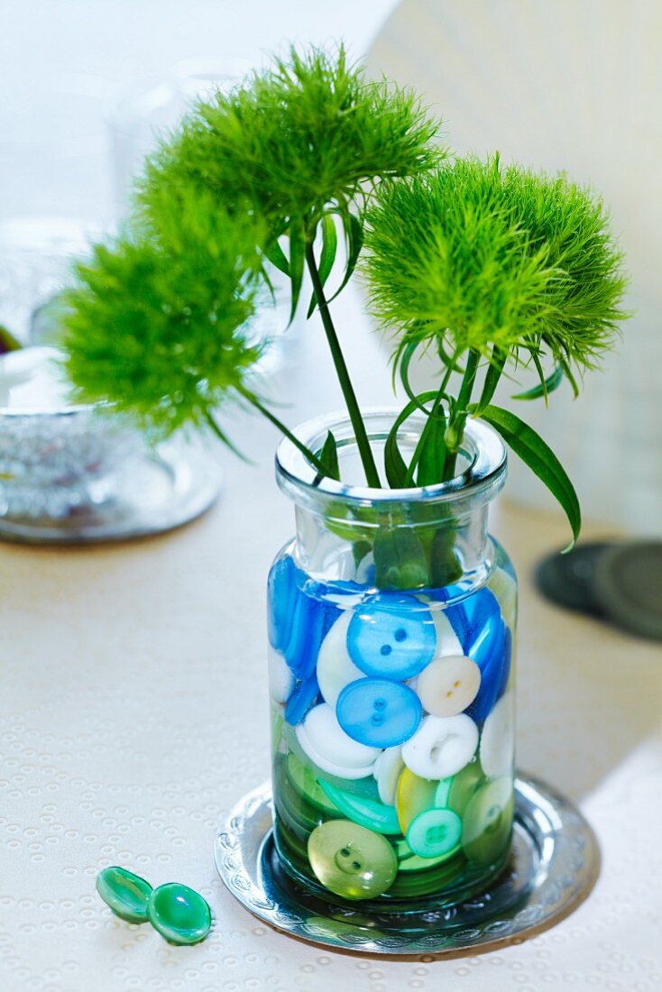 Vase of flowers decorated with buttons in water