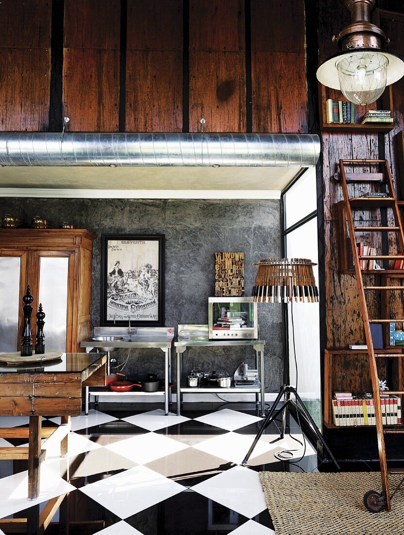 Warm wood hues and industrial elements in corner of interior with glossy, chequered floor