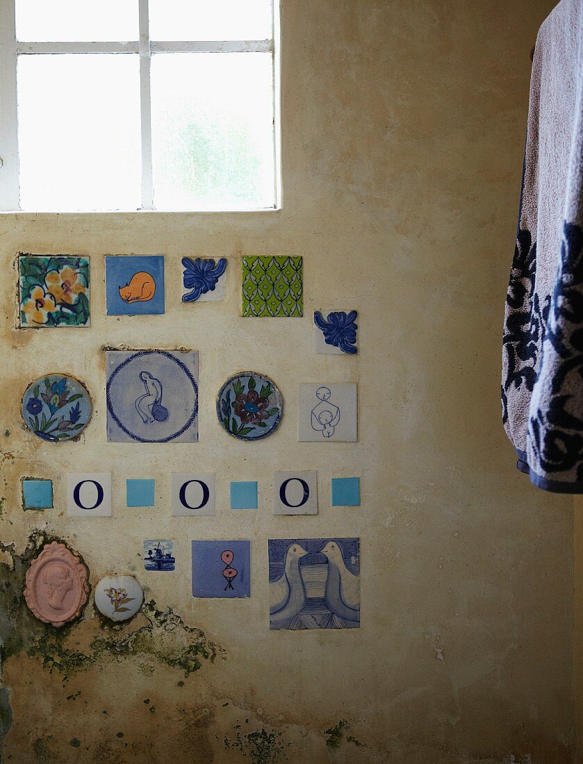 Decorative wall tiles with motifs of animals and flowers on rustic wall
