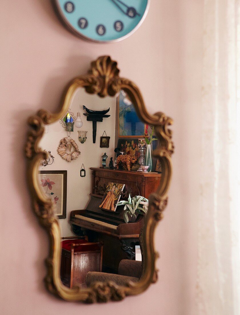 Antiker Spiegel mit geschnitztem Holzrahmen und sich spiegelndem Klavier