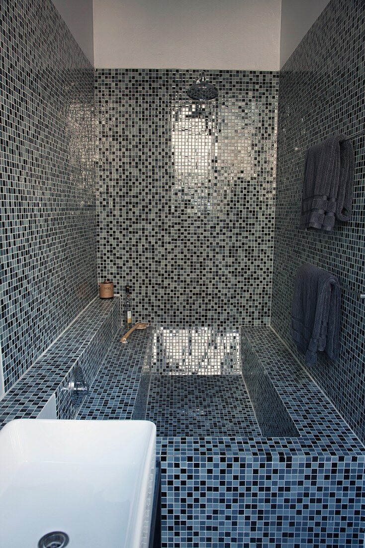 Spa-Gefühl in schmalem Badezimmer mit blauen und schwarzen Mosaikfliesen