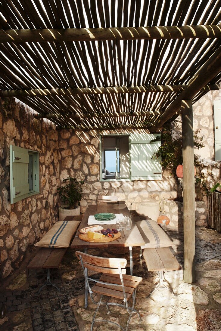 Rustic terrace with simple sunshade made from long bamboo poles and stone floor