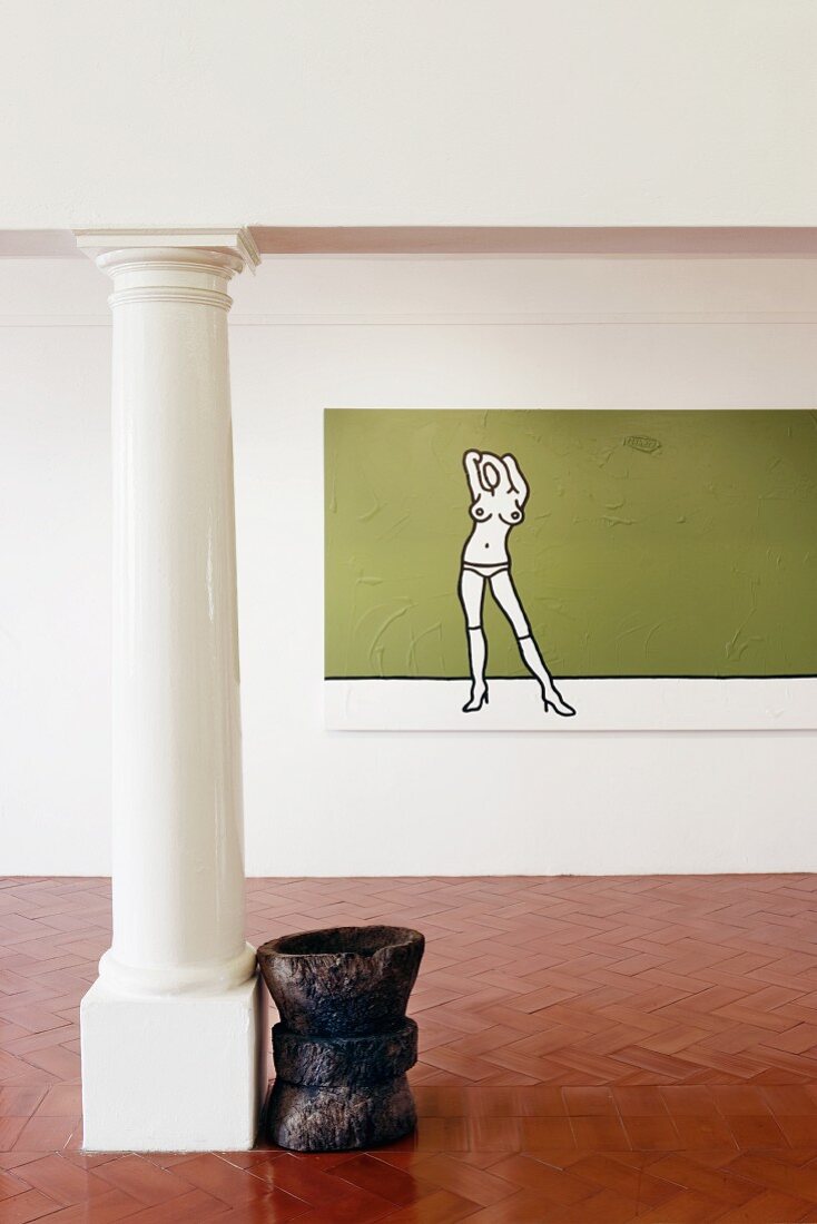 Unmöblierter Raum mit modernem Gemälde an der Wand und Holzobjekt neben klassischer Säule