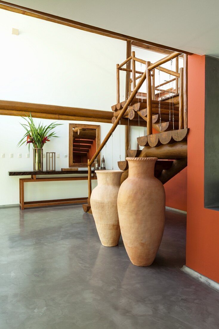 Interior with wooden staircase and floor vases