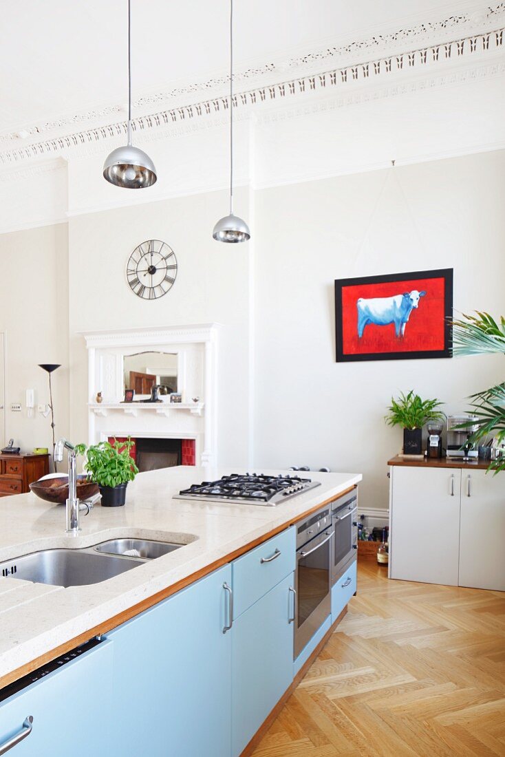 Freistehende Kücheninsel mit Spülbecken und Gaskochfeld in herrschaftlichem Wohnraum mit umlaufendem Stuckfries an Decke
