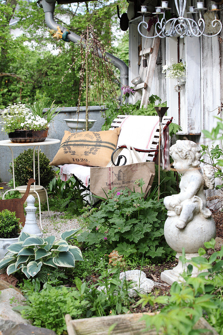 Mit Trödel dekorierter Garten und Sitzplatz vor dem Gartenhäuschen
