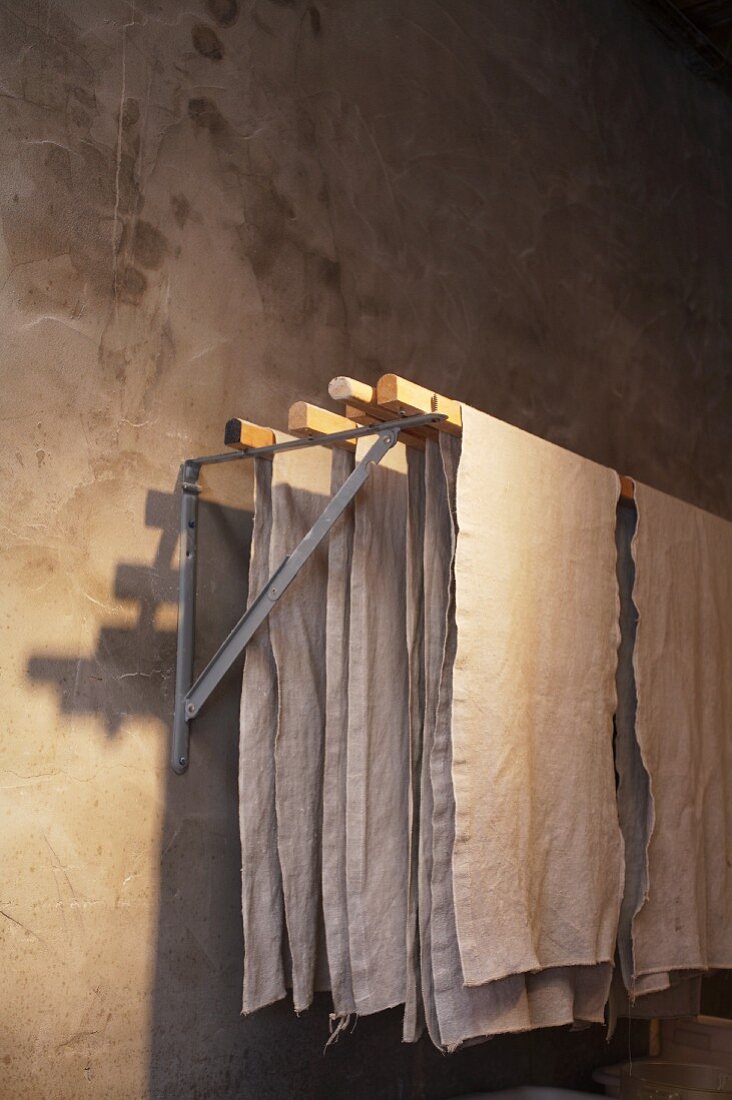 Linen cloths on wall-mounted clothes airer