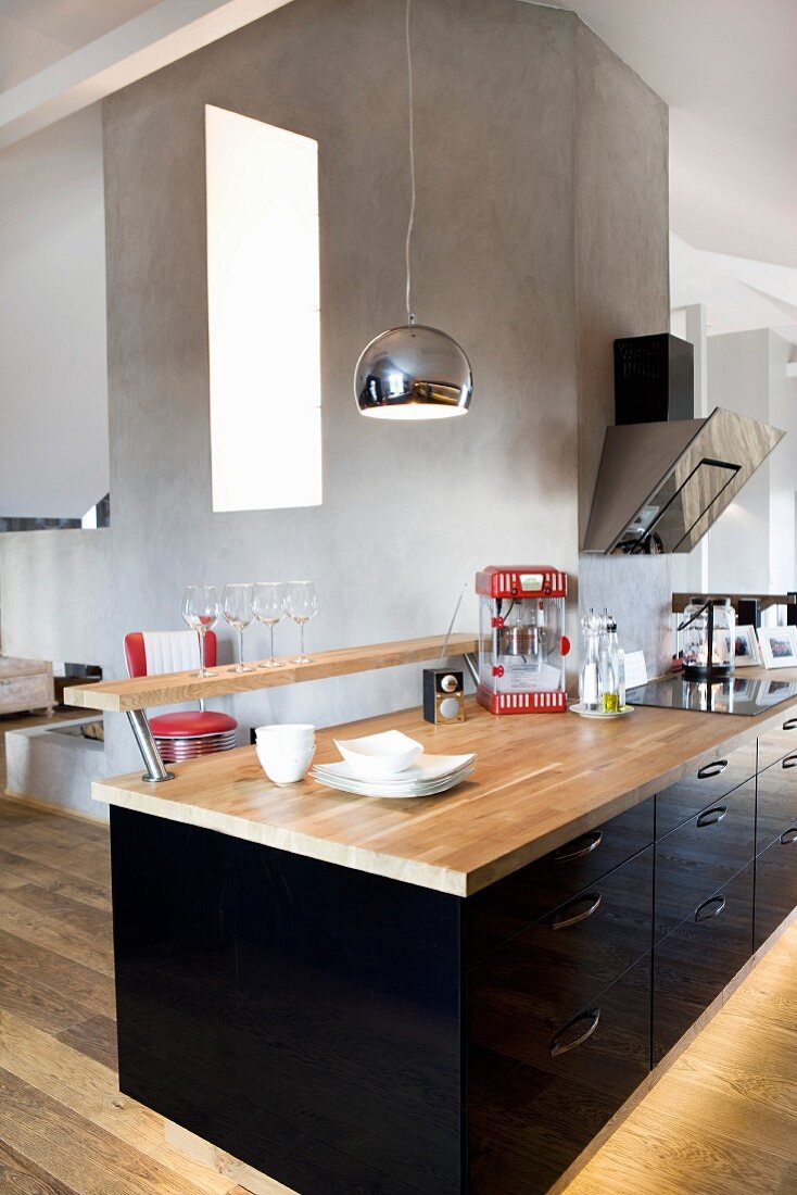 Schwarzer Hochglanz Küchenblock mit Theke und Holz- Küchenarbeitsplatte in offenem Wohnbereich eines Dachgeschosses