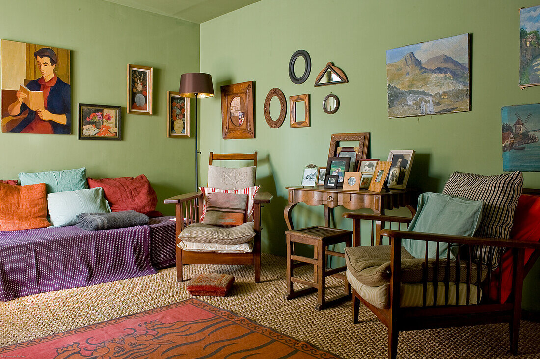 Wohnzimmer mit gemischten Vintage-Möbeln und mehreren Wandbildern