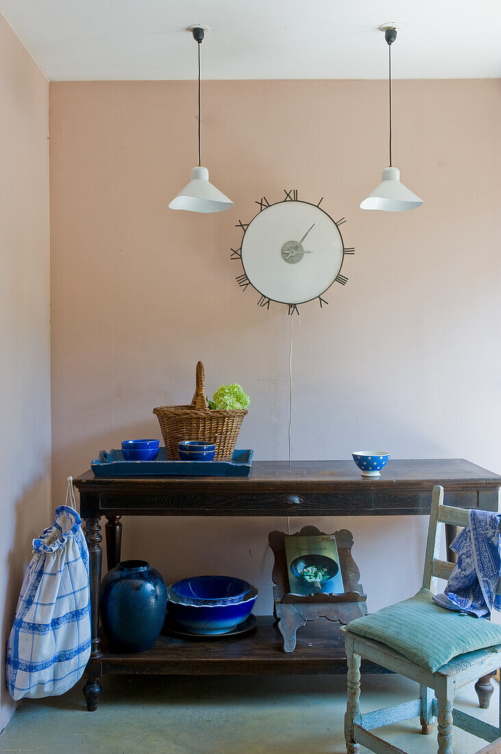 Rustikaler Tisch mit blauer Keramik und Wanduhr im Landhausstil