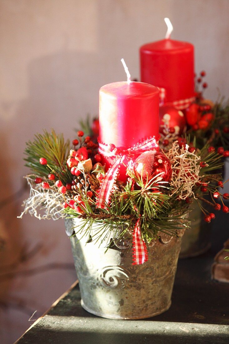 Rustikale Weihnachtsdeko mit Zweigen und Kerze im Pflanztopf