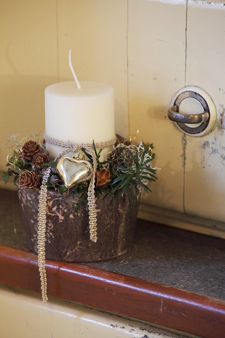 Festively decorated candle and twigs in pot