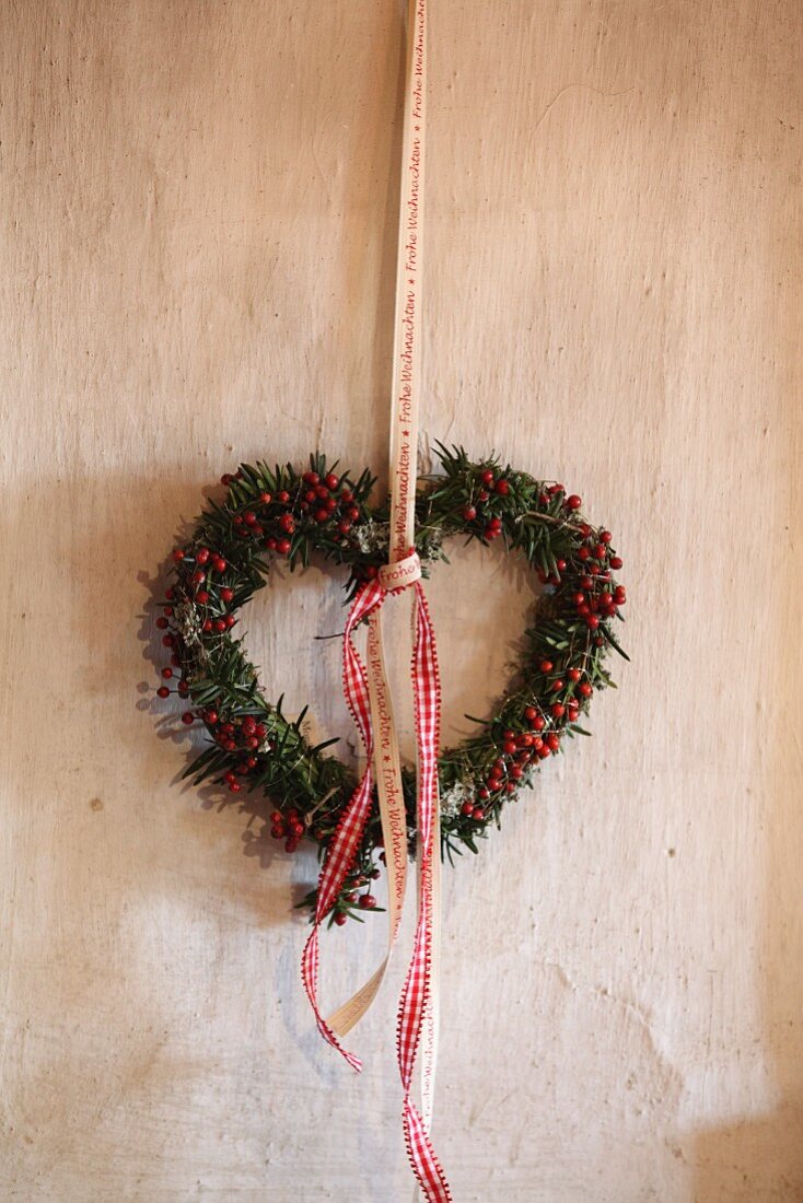 Heart-shaped wreath of berries hung from ribbon