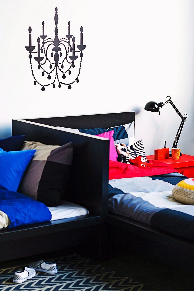 Original siblings' bedroom with chandelier painted on wall and twin beds arranged in an L