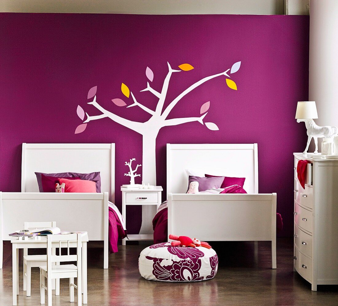 Elegantly designed bedroom for two sisters - twin beds against purple wall with stylised tree mural