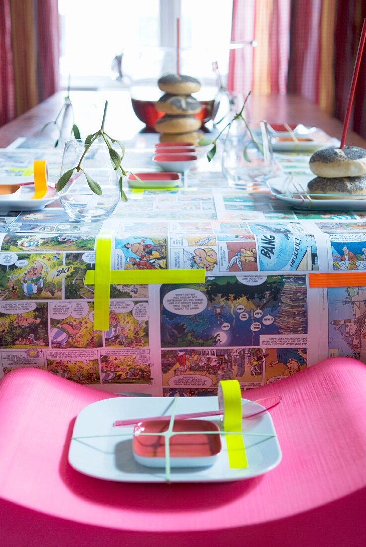 Gedeckter Tisch für Kindergeburtstag, Tischdecke mit Asterix und Obelix Motiven und bunten Klebestreifen