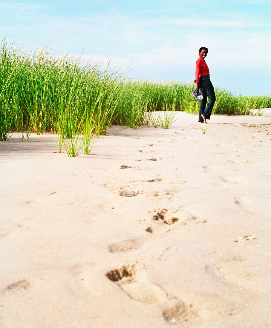 Junge Frau hinterlässt Fußspuren im Sand