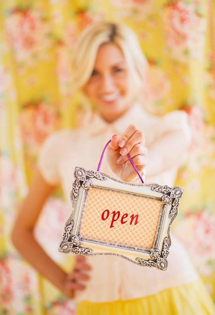Young woman hold an 'open' sign