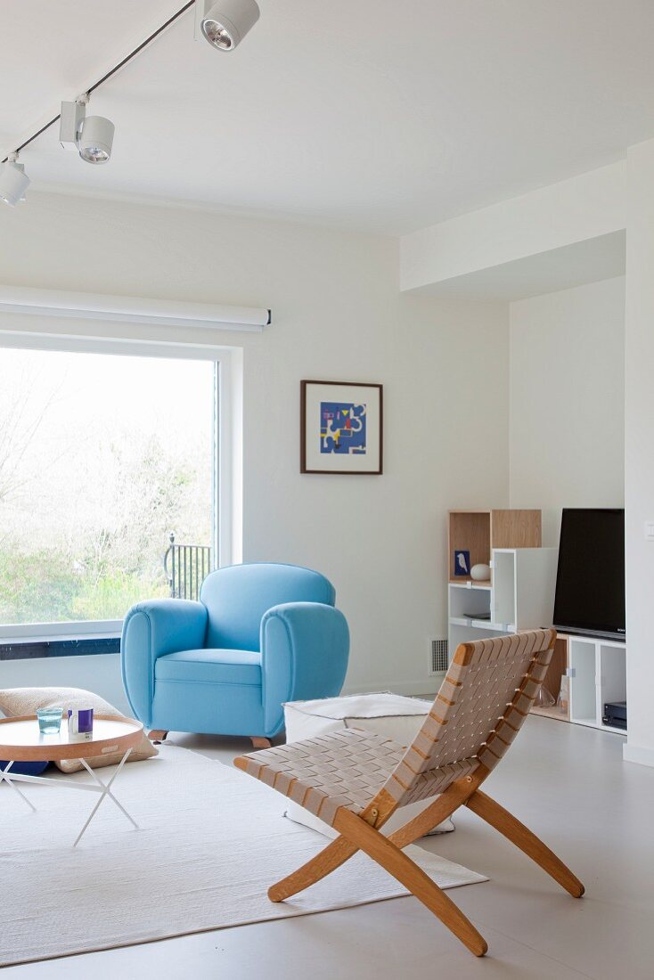 Pale blue armchair in Scandinavian interior with minimalist furnishings