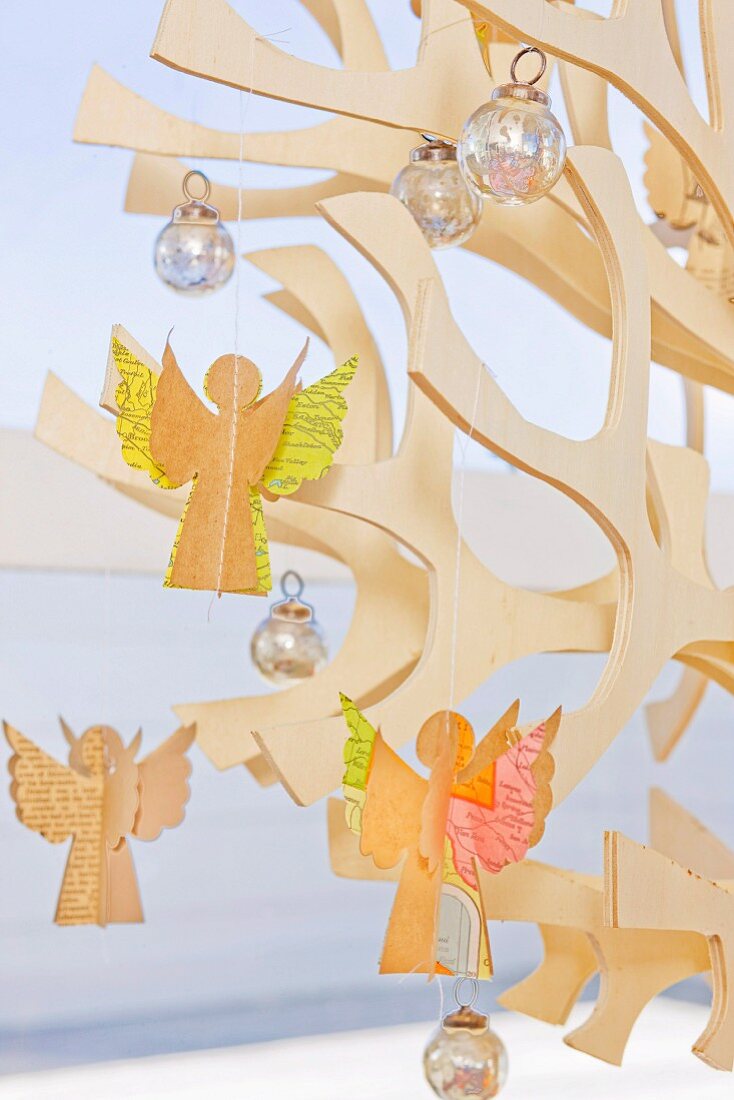 Selbst gebastelte Engelsfiguren aus Papier auf stilisiertem Weihnachtsbaum