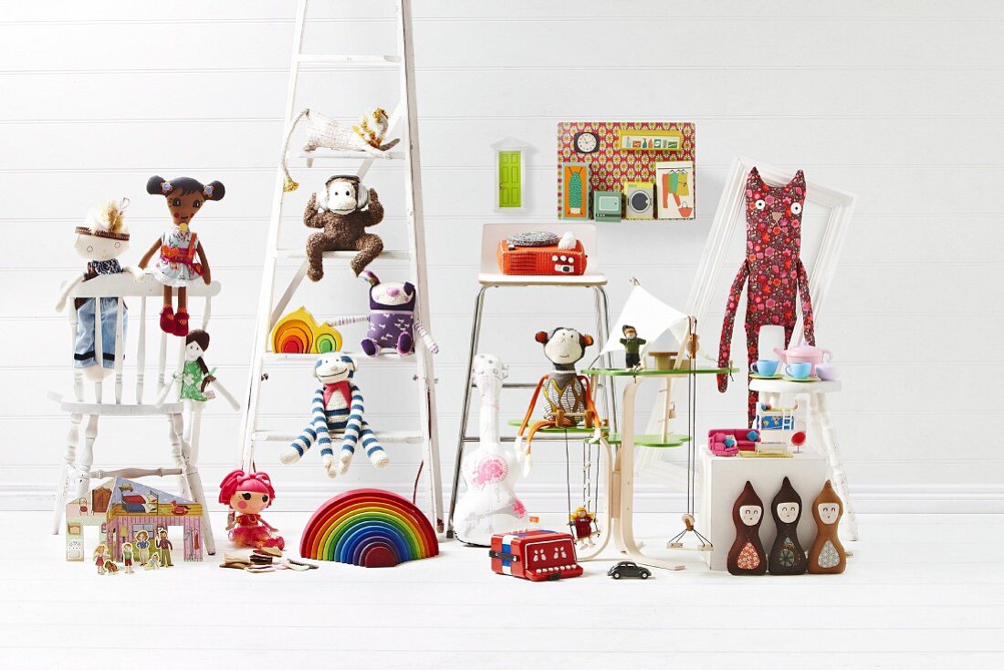 Auf verschiedenen Möbelstücken verteiltes Kinderspielzeug