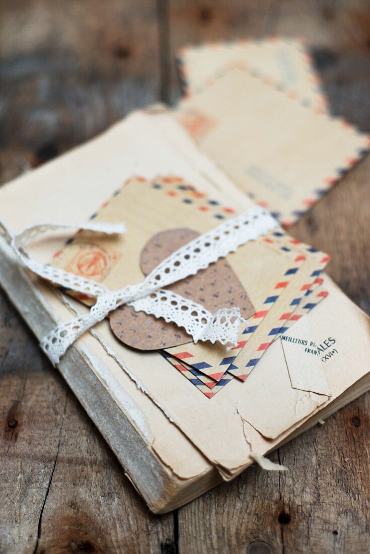 Old book and letters tied up with lace ribbon