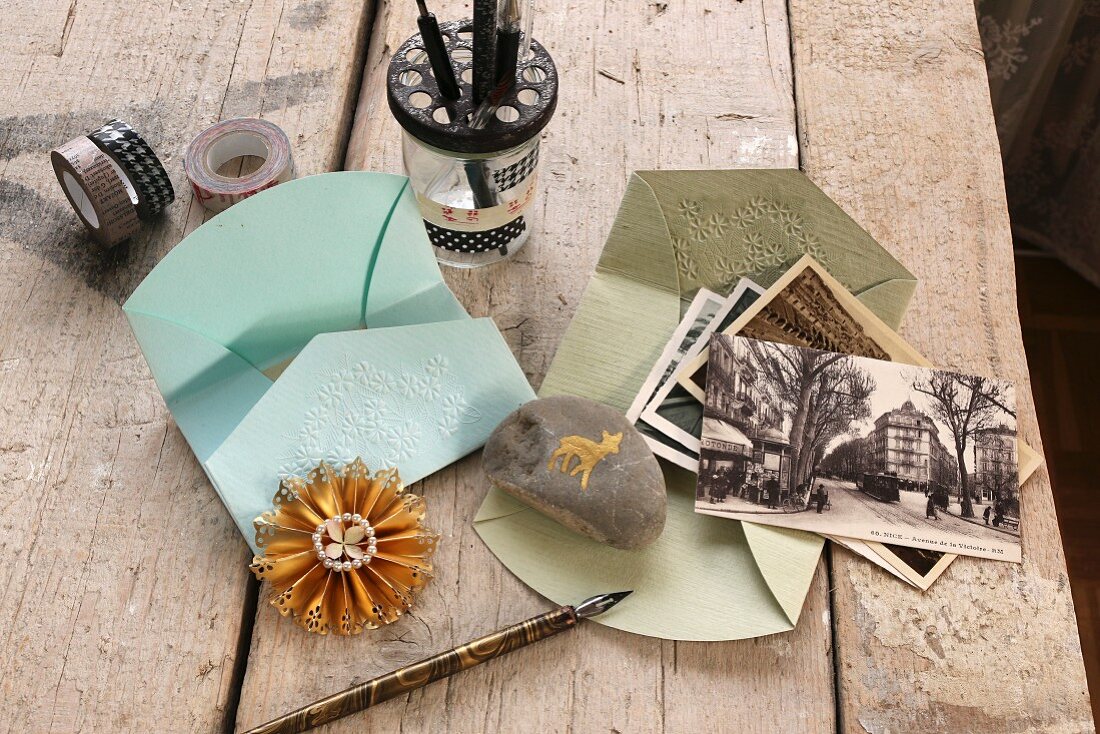 Embossed envelopes, pebble as paper weight, dip pens and old postcards