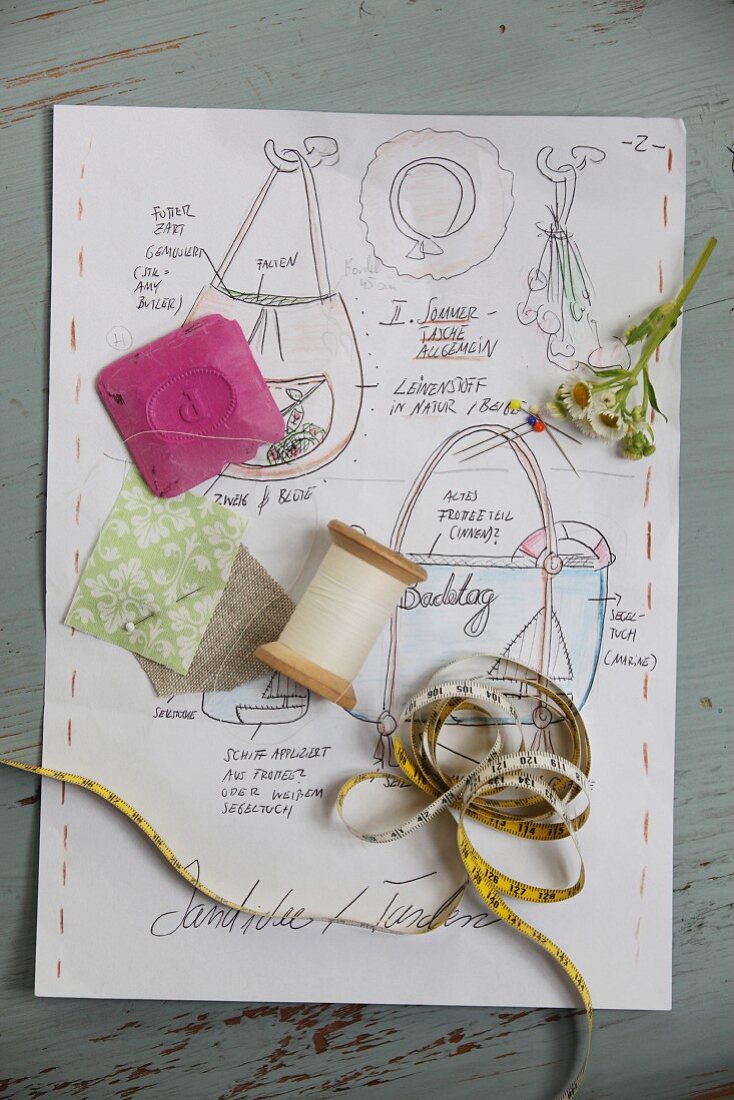 Various sewing utensils on sketch with instructions for making a bag