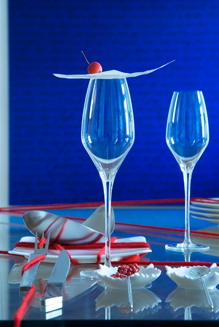Oriental place setting: thin sheet of pastry and crab apple on stemmed glass